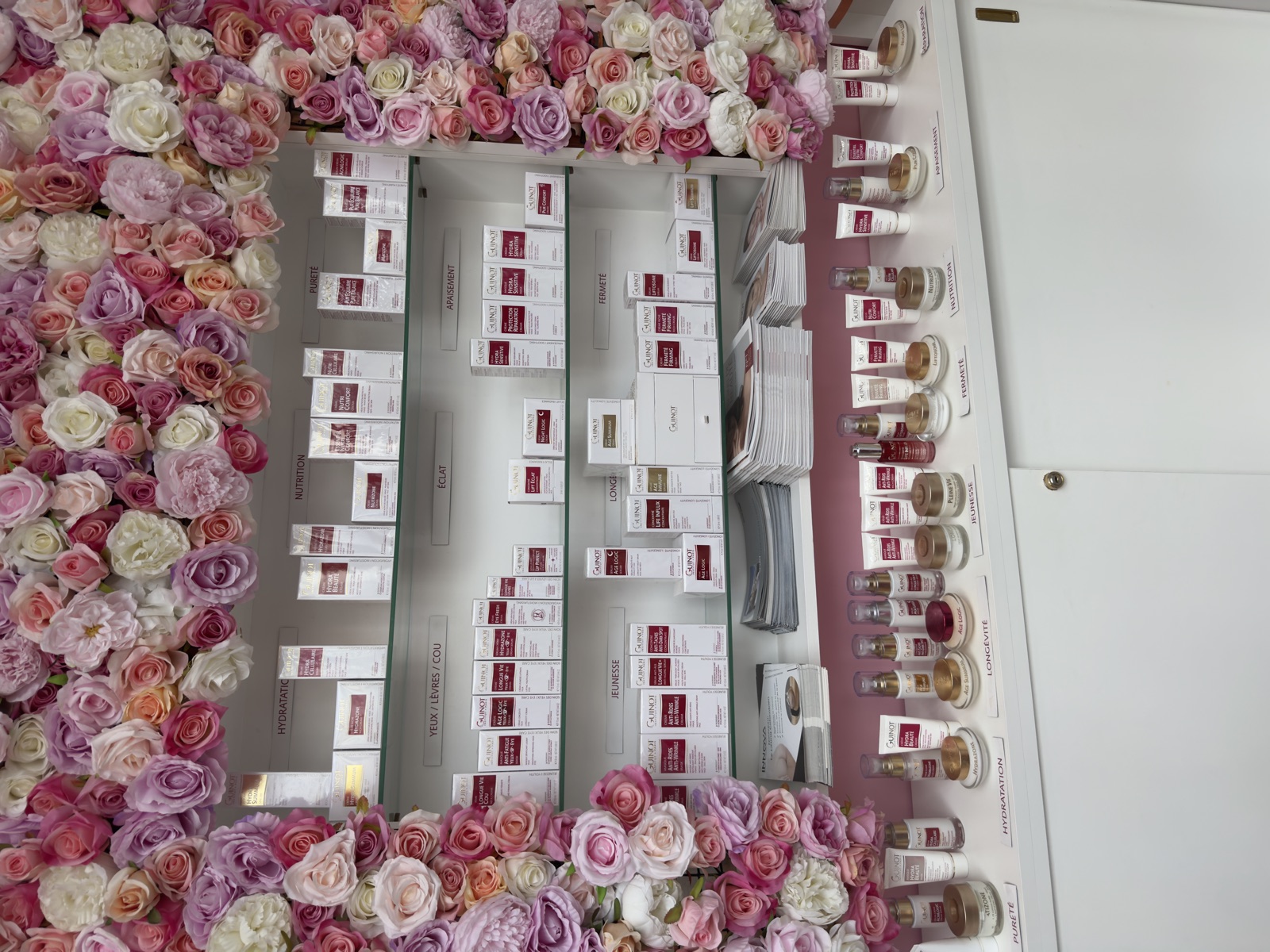 Le mur de présentoirs Guinot, le long du mur de fleurs